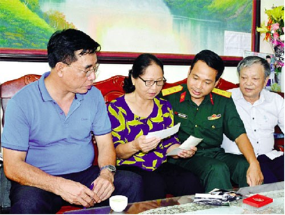 Bà Nguyễn Thị Thịnh giới thiệu những kỷ vật thời quân ngũ với cựu chiến binh và cán bộ Lữ đoàn 205.
            Ảnh: Dũng Hà.